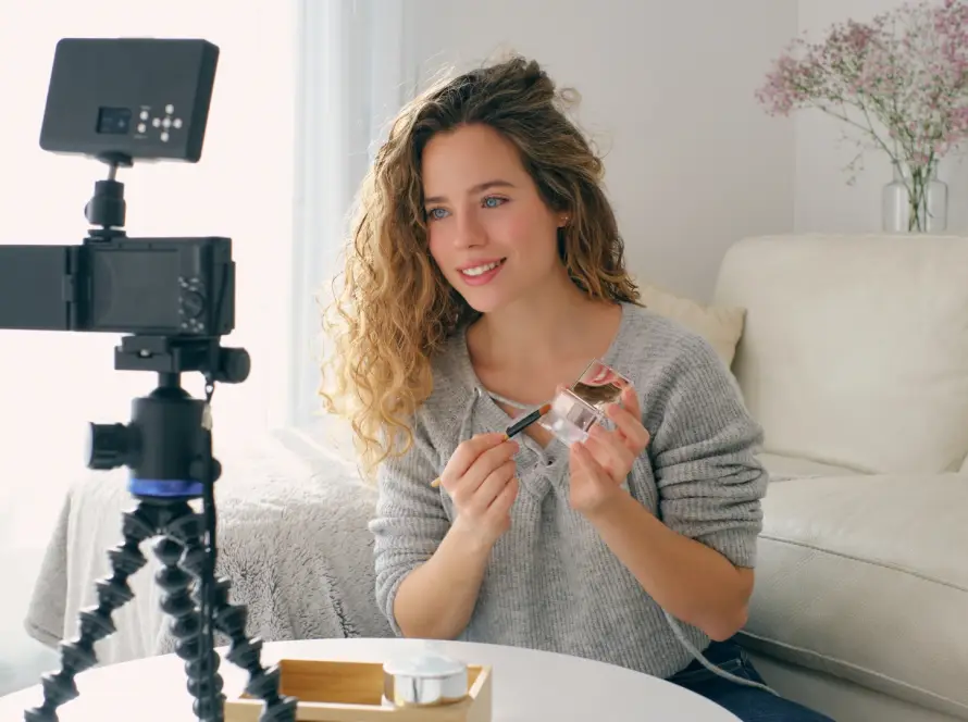 incluencer frente a la cámara mostrando productos promocionados